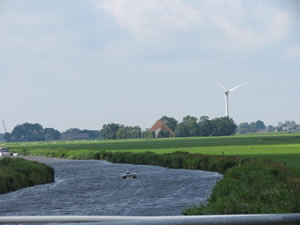 Solar boat with a modern windmill in the background