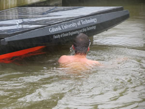 A swimmer from the Gdansk team goes diving to clear the boat's propeller